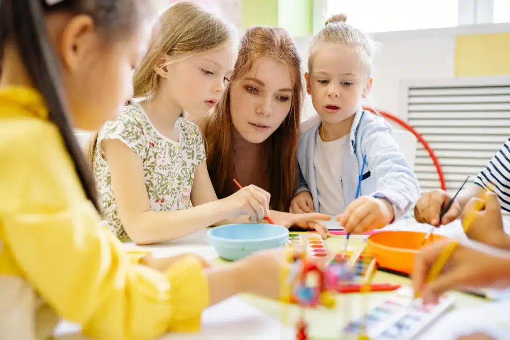 Afbeelding van kinderen van 4 tot 8 jaar die spelen en begeleid worden door een mbo-student, passend bij keuzedeel BSO 4-8 jaar (K0793).